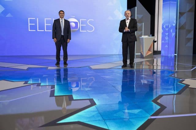 Debate eleitoral entre Flávio Bolsonaro e Lula em estúdio de televisão