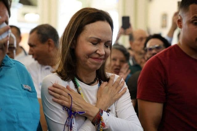 María Corina Machado cumprimentada por apoiadores ao chegar a uma igreja na Venezuela