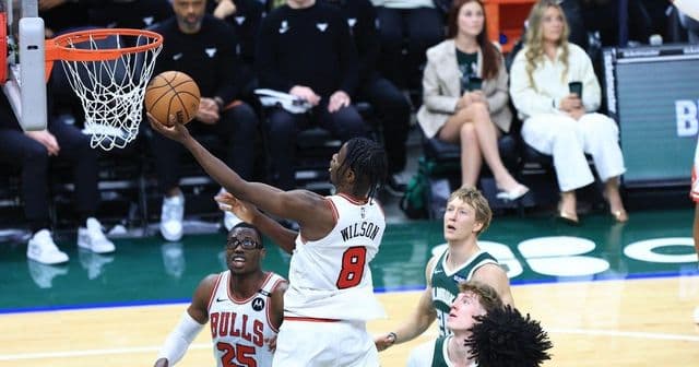 Jogadores de basquete disputando uma bola em uma quadra de jogo da NBA