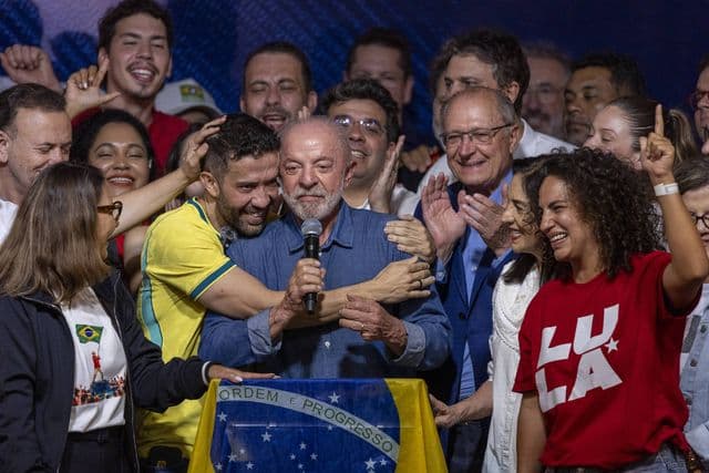 Lula discursa no palco após a vitória nas eleições de 2026, cercado por aliados e políticos jovens