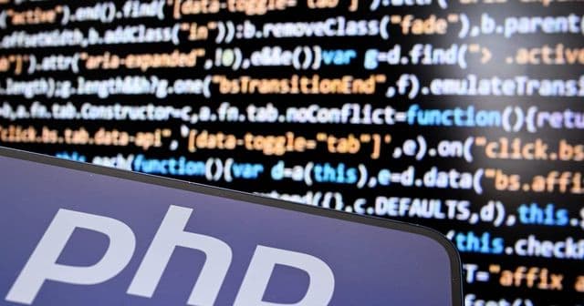 Logotipo do PHP exibido na tela de um smartphone ao lado de código em um notebook
