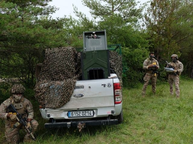 Militar francês operando óculos de visão FPV em área de treinamento em Mailly-le-Camp