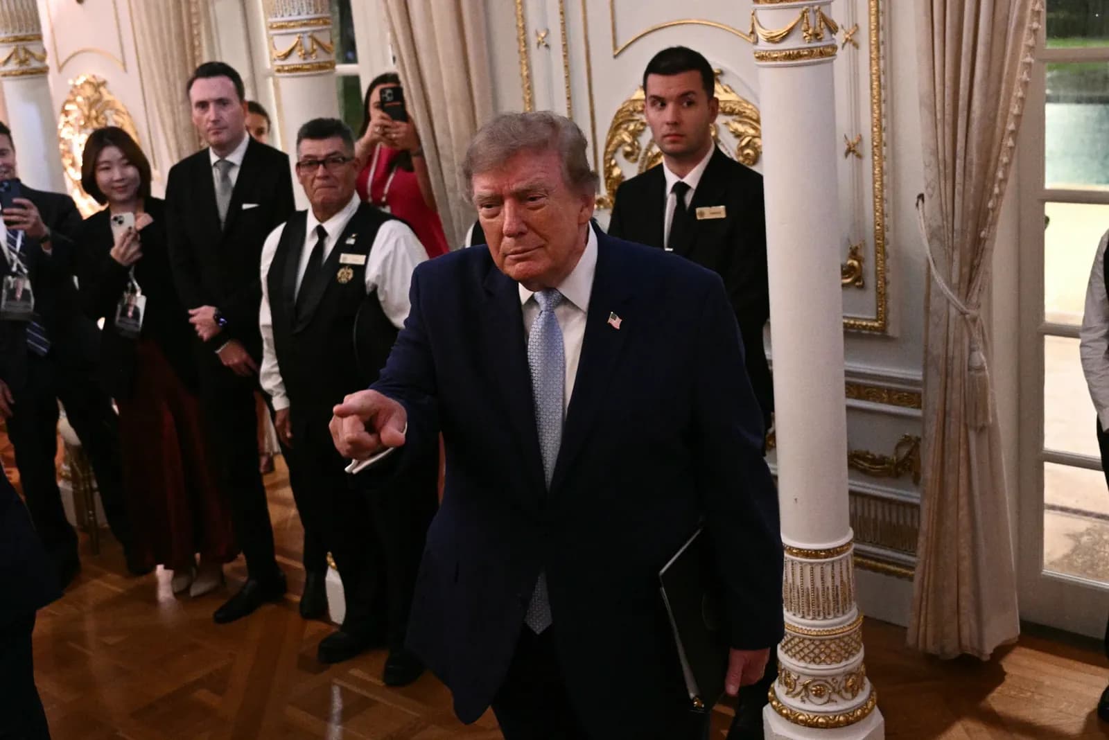 Donald Trump em pronunciamento, com bandeiras dos Estados Unidos ao fundo