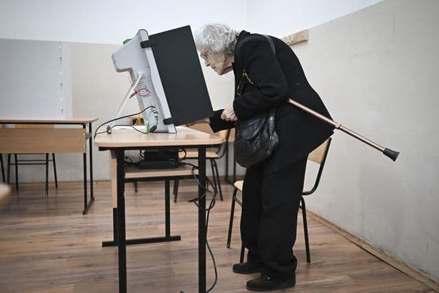 Eleitores búlgaros em seção de votação
