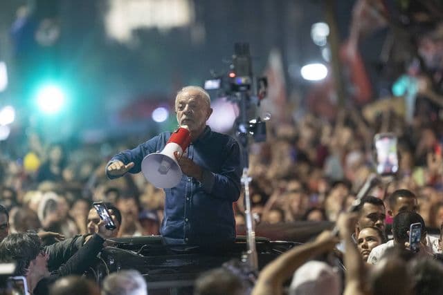 Presidente Lula em pé sobre o teto solar de um GWM Haval H6 preto em São Paulo