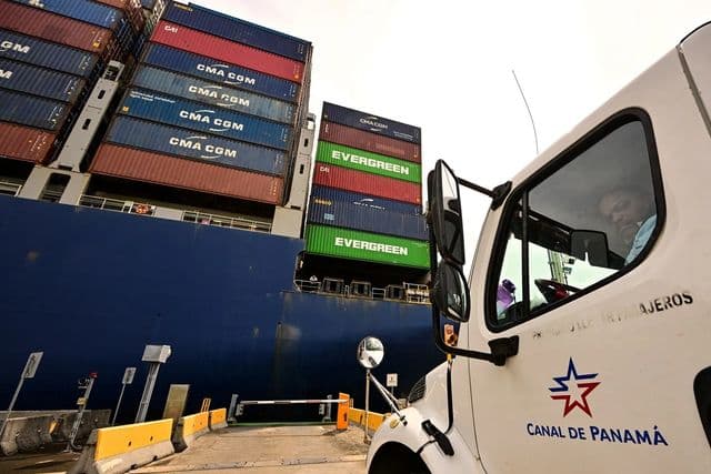 Navio de carga atracado em terminal portuário com contêineres empilhados